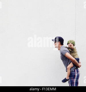 Padre dando il proprio figlio un piggyback ride Foto Stock