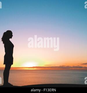 Silhouette di una donna che guarda al mare al tramonto, Tenerife, Isole Canarie, Spagna Foto Stock
