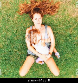 Vista aerea di una donna sdraiata su erba con sua figlia Foto Stock