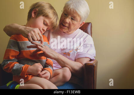 Ragazzo seduto sulla sua nonna lap Foto Stock