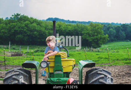 Ritratto di un ragazzo seduto su un trattore Foto Stock