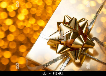 Decorate confezione regalo con fiocco su blur sullo sfondo Foto Stock