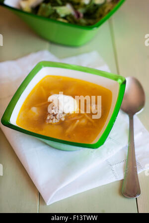 Zuppa con polpette di carne e insalata su uno sfondo di legno Foto Stock