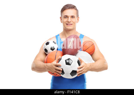 Giovane atleta tenendo un mazzetto di differenti tipi di palle sportive isolati su sfondo bianco Foto Stock