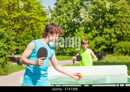 Due ragazzi insieme giocando a ping pong al di fuori Foto Stock