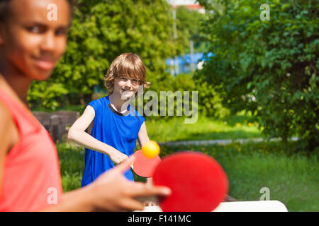 Due amici sorridenti insieme giocando a ping-pong Foto Stock