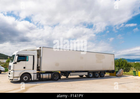 White carrello equipaggiato con merci di refrigerazione parcheggiato in una stazione di benzina in Spagna Foto Stock