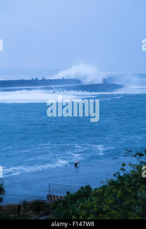 Parete barriera in spiaggia con le onde del mare durante la tempesta Foto Stock
