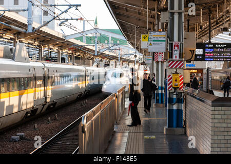 Shin stazione di Okayama. Vista lungo la piattaforma con protezione sventolando in avanti shinkansen, bullet train, come si arriva. Di fronte è un N700 serie Star rampa treno. Foto Stock