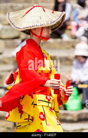 Giappone, Tsuyama. Primavera Cherry Blossom Festival di Kakuzan Park. Bambino in linea, indossando la tradizione yukata camicia e indossa cappello di paglia, ballare. Foto Stock