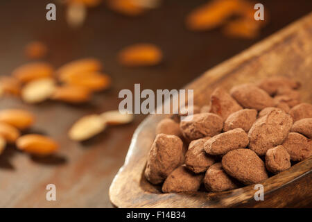 Cioccolato fondente mandorla tartufi su sfondo di legno. Foto Stock