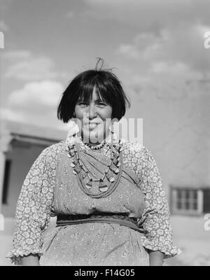 1930s sorridente Native American Indian donna che indossa il tipico abito & gioielli guardando la telecamera SAN ILDEFONSO PUEBLO NEL NUOVO MESSICO USA Foto Stock