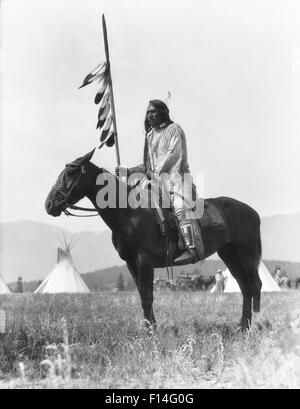 1920s SINGLE NATIVE AMERICAN STONEY indiani Sioux uomo seduto sul cavallo HOLDING EAGLE FEATHERED DECORATE LANCIA ALBERTA CANADA Foto Stock