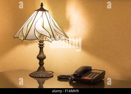 Lampada da tavolo e il telefono sulla scrivania Foto Stock