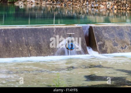 Acqua fluente rilasciato dall'apertura paratoie di una diga Foto Stock