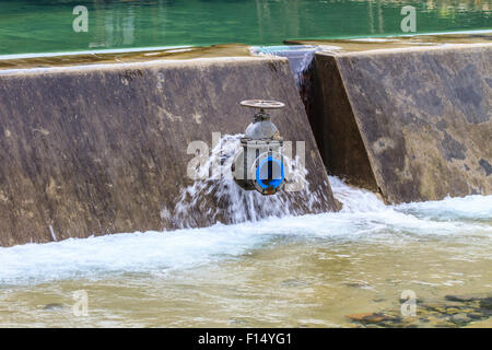 Acqua fluente rilasciato dall'apertura paratoie di una diga Foto Stock