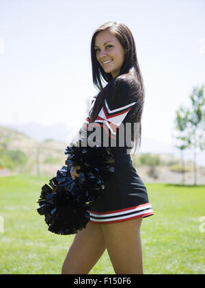 Stati Uniti d'America, Utah, American forcella, Ritratto di sorridere cheerleader holding pom-pom Foto Stock