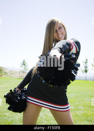 Stati Uniti d'America, Utah, American forcella, Ritratto di sorridere cheerleader holding pom-pom Foto Stock