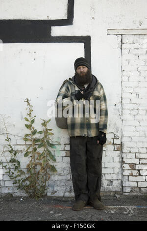 Stati Uniti d'America, Utah, Salt Lake City, senzatetto uomo in piedi di fronte a un muro di mattoni Foto Stock