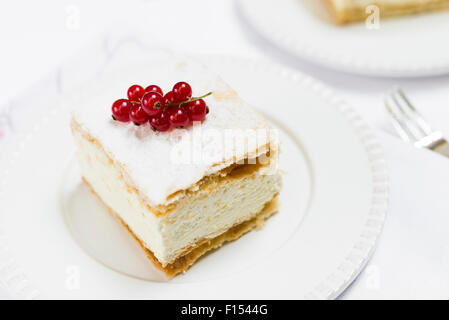 Close up di Polish cream pie e rabboccato con ribes rosso sulla piastra bianca Foto Stock