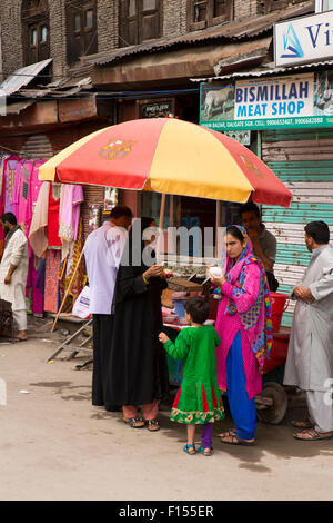 India, Jammu e Kashmir Srinagar, Dalgate, colurfully vestito le donne mangiare il gelato sotto l'ombra di ombrello Foto Stock