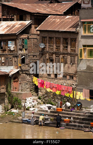 India, Jammu e Kashmir Srinagar, città vecchia, uomini il lavaggio di tessuti in fiume Jhelum su riverside ghat Foto Stock