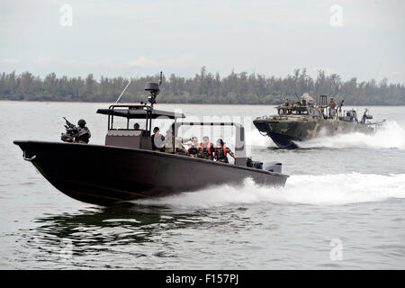 Stati Uniti Navy SEALs con la costiera squadrone fluviale 4 lungo con Royal Malaysian speciali forze di operazione condotta tattica in barca durante la formazione carrello Malaysia esercizi di addestramento Agosto 18, 2015 in Sandakan, Malaysia. Foto Stock