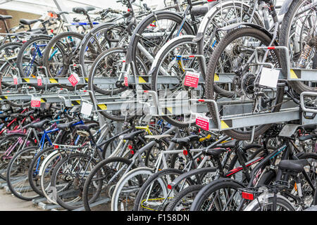 Molti commuter Biciclette parcheggiate e bloccato al di fuori di una stazione ferroviaria a Chelmsford Essex in agosto 2015 forniscono ecologici tra Foto Stock