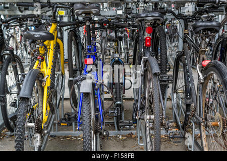 Molti commuter Biciclette parcheggiate e bloccato al di fuori di una stazione ferroviaria a Chelmsford Essex in agosto 2015 forniscono ecologici tra Foto Stock