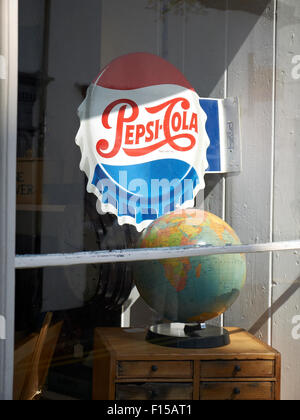 Pepsi-cola segno con globo mondo sul display nel negozio di antiquariato UK Foto Stock