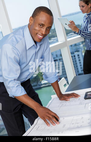 Ritratto di un giovane imprenditore sorridente lavorando in ufficio Foto Stock