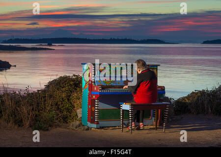 Senior Citizen donna suonare il pianoforte colorato prima dell'alba-Victoria, British Columbia, Canada. Foto Stock