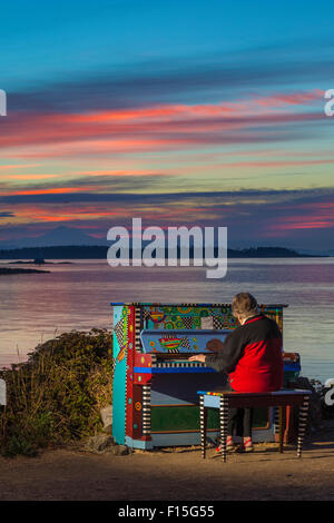 Senior Citizen donna suonare il pianoforte colorato prima dell'alba-Victoria, British Columbia, Canada. Foto Stock