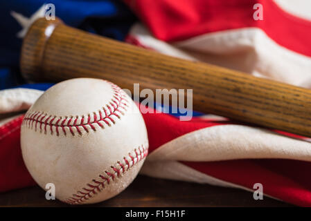 Un vecchio, antichi bandiera americana con vintage attrezzatura da baseball su una panca in legno Foto Stock