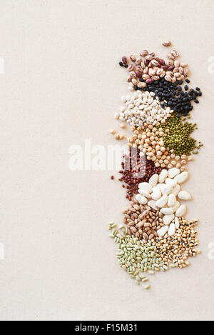 Pile di fagioli secchi e legumi, studio shot su sfondo beige Foto Stock