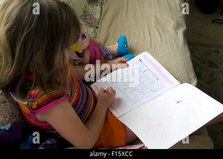 6 anno vecchia ragazza mettere in pratica le capacità di scrittura in compiti prenota Foto Stock