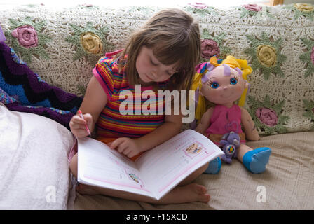 6 anno vecchia ragazza mettere in pratica le capacità di scrittura in compiti prenota Foto Stock