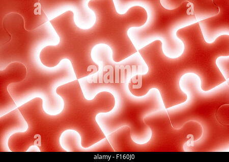 Sullo sfondo di un grande puzzle brillante in rosso Foto Stock