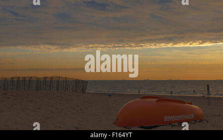 Sunset umore con barca capovolta del bagnino, sulla spiaggia di Katwijk aan Zee, South Holland, Paesi Bassi. Foto Stock