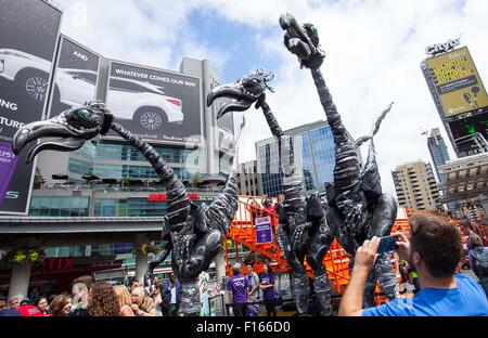 Toronto, Canada. Il 27 agosto, 2015. Buskers da Paesi Bassi eseguire un costume stilt show con 18 piedi di altezza i dinosauri durante il 2015 Internazionale di Toronto a BuskerFest Yonge-Dundas Square a Toronto, Canada, 27 agosto 2015. I quattro giorni del festival ha dato dei calci a fuori il giovedì. Credito: Zou Zheng/Xinhua/Alamy Live News Foto Stock