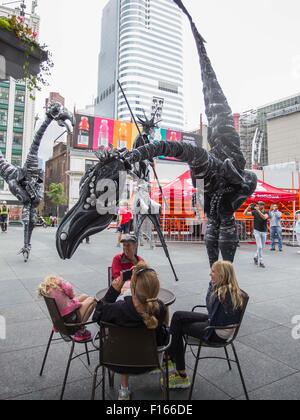 Toronto, Canada. Il 27 agosto, 2015. Buskers da Paesi Bassi eseguire un costume stilt show con 18 piedi di altezza i dinosauri durante il 2015 Internazionale di Toronto a BuskerFest Yonge-Dundas Square a Toronto, Canada, 27 agosto 2015. I quattro giorni del festival ha dato dei calci a fuori il giovedì. Credito: Zou Zheng/Xinhua/Alamy Live News Foto Stock