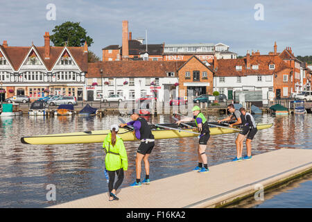 Inghilterra, Oxfordshire, Henley-on-Thames, lo skyline della città e vogatori sul Fiume Tamigi Foto Stock