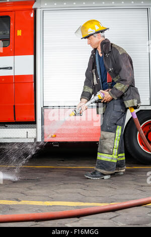 Vigile del fuoco la spruzzatura di acqua sul pavimento durante il corso di formazione Foto Stock