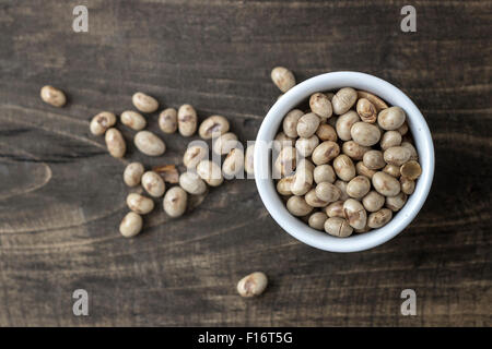 Arrosto di fagioli di soia in un recipiente su sfondo di legno Foto Stock