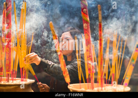 Il Vietnam Thien Hau pagoda, una donna vietnamita compie un atto di culto presso il Tempio Thien Hau in Cholon , Ho Chi Minh City, a Saigon, Vietnam Foto Stock