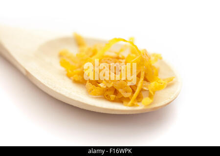 Fresco scorza di limone su un cucchiaio di legno, su sfondo bianco Foto Stock