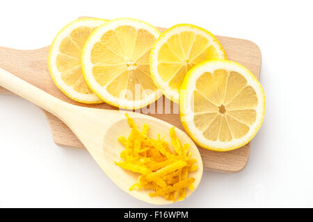 La scorza di limone e fette di limoni su un taglieri, gli ingredienti per un dessert Foto Stock
