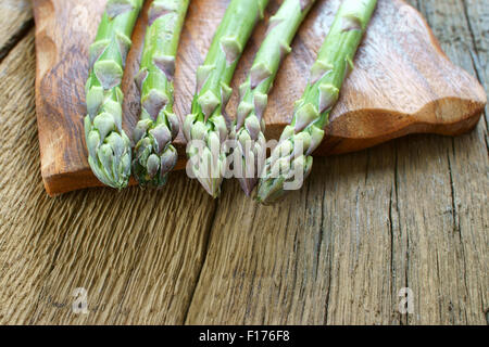 Mazzetto di freschi Asparagi verdi spears su una tavola in legno rustico Foto Stock