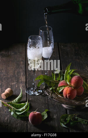 Le pesche sul ramo con champagne Foto Stock