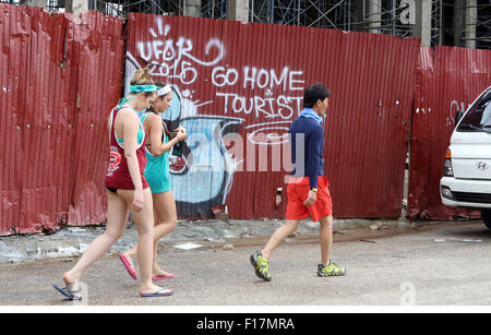 Vai turistico Home graffiti sul muro di ragazze a piedi passato Foto Stock